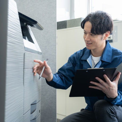 コピー機のメンテナンスをするスタッフ