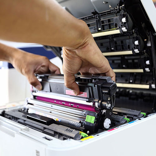 コピー機をメンテナンスする男性の手元のアップ写真
