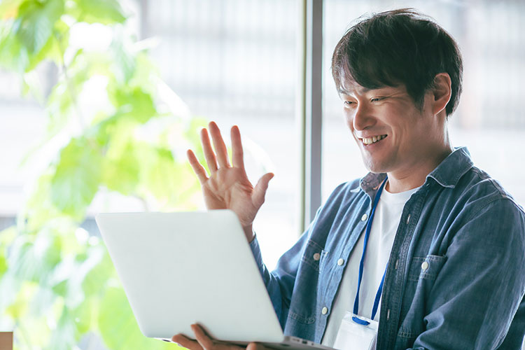 笑顔でPCを見る男性の写真